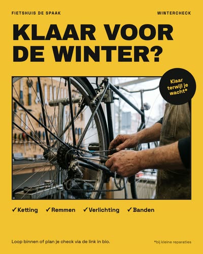 Een gele poster met een foto van een fietsenmaker die een achterwiel afstelt, met de tekst: Klaar voor de winter? Ketting, remmen, verlichting, banden. Klaar terwijl je wacht, bij kleine reparaties. Fietshuis De Spaak.